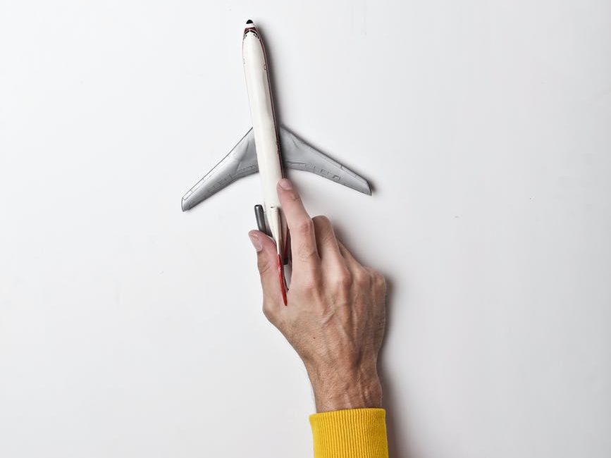 male hand with white toy plane